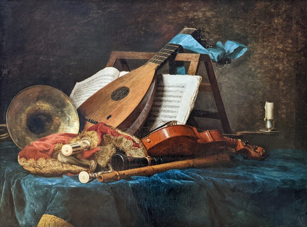 Still-life painting of musical instruments on a table with a blue tablecloth.  A lute and an open book of sheet music are propped up on a tabletop music stand in the center, surrounded by a horn, bagpipe, transverse flute, clarinet, and violin.